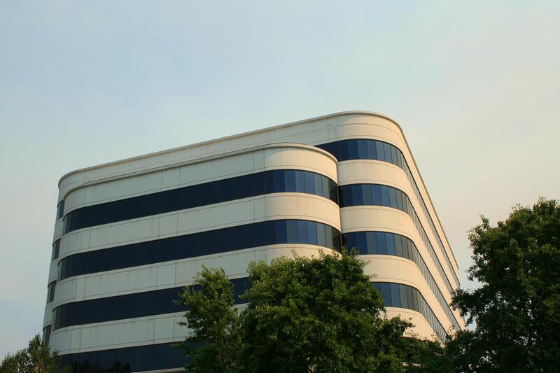 Picture of large commercial white building with window tinting